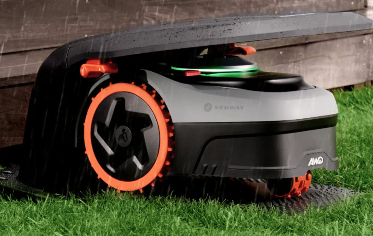 Cleaning robotic mower underside with brush after wet weather